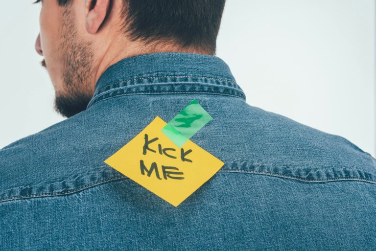 back view of man with note on sticky tape with kick me lettering on back, april fools day holiday